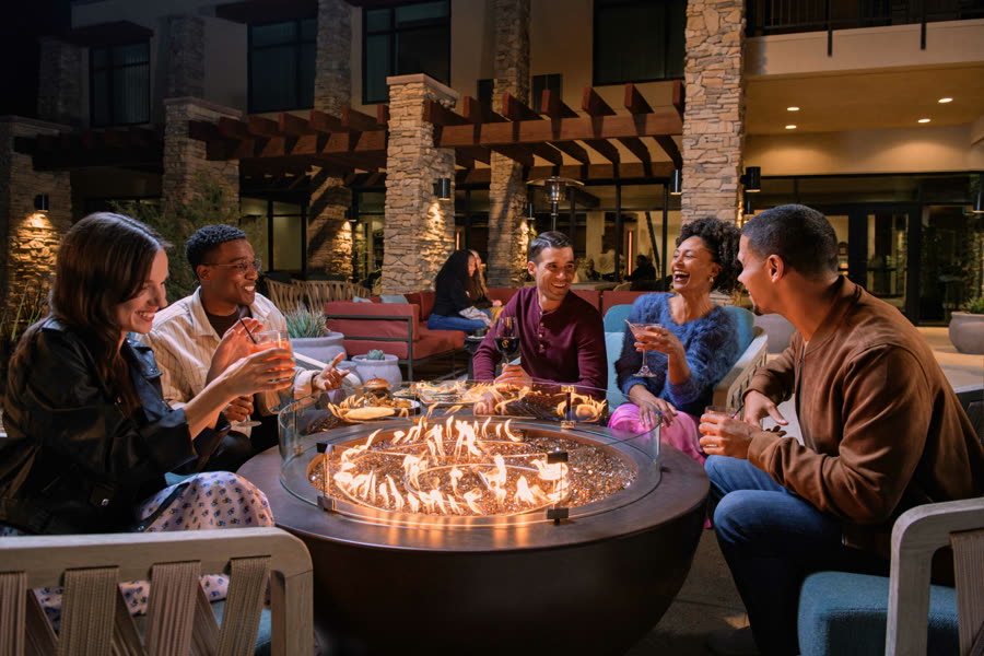 Guests around a fire pit at The Eddy in Tucson, a Hilton Tapestry Collection hotel